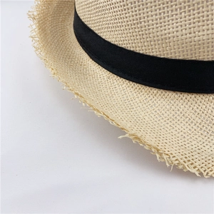 Macro view of woven straw sun hat texture with black ribbon and frayed brim edges
