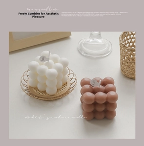 Macro detail of white and brown rubik's cube candles with round paper tags on a tray