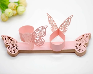 Detail of pink laser-cut butterfly napkin rings for weddings and formal dining