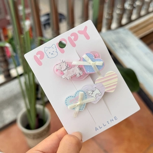 Detail of candy-colored Westie dog hair clips with bows on display packaging card