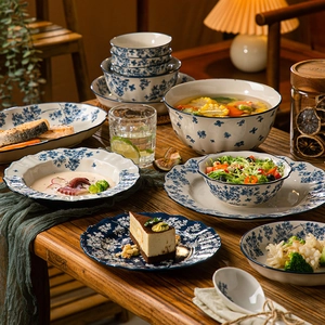 Chinese blue and white porcelain dinnerware set with floral patterns on a wooden table
