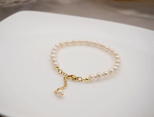 Close-up of elegant white freshwater pearl bracelet on a minimalist white plate