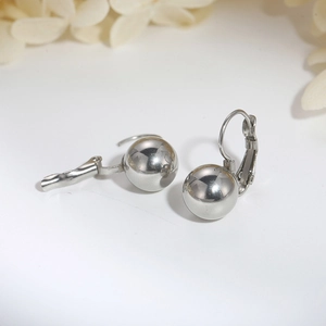 Macro shot of silver stainless steel ball earrings with polished finish and leverback hook