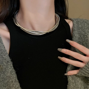 Close-up of a silver multi-layered twisted chain necklace on a model's neck