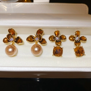 Detail of two pairs of 18K gold plated vintage flower earrings with pearls and crystals