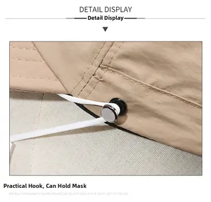Close-up of beige sun hat detail featuring a metal hook for face mask attachment