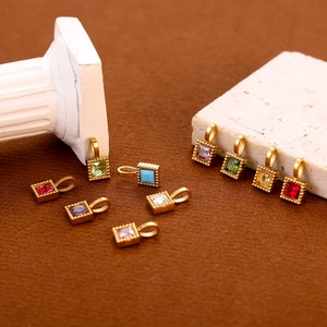 Square zircon pendants in various colors with gold-plated bezel on plush background