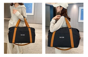 Large capacity black travel tote bag with brown straps shown in use by a model