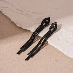 Macro shot of black tassel earrings with zircon geometric chains and silver pins