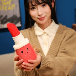 Creative plush lipstick doll with a smiling face held by hands in a home setting