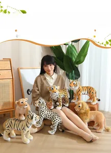 Detailed view of realistic plush tiger and lion cubs held by a person for size display