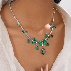Macro view of emerald green crystal butterfly pendant necklace on model neck