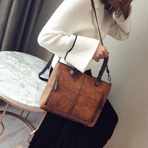 Vintage brown oil leather tote bag with double front zippers shown on a shoulder