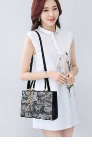 Dettaglio della borsa tote floreale bianca e nera con logo Miss Gal e tracolla nera
