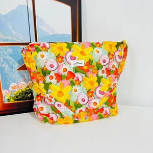 Floral canvas shoulder bag with colorful flower patterns and white brand label on front