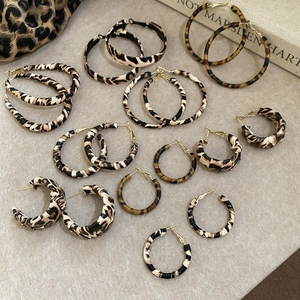Macro view of various leopard print wrap hoop earrings in different sizes and styles