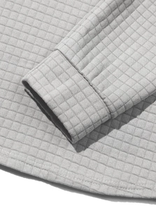 Detail of grey waffle knit sweater cuffs and hem with precise stitching craftsmanship