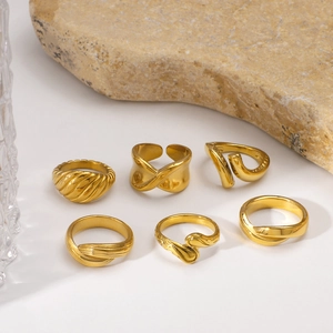 Collectie geometrische 18K vergulde roestvrijstalen ringen op een strakke witte achtergrond