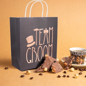 Elegant black Team Groom gift bag for wedding favors with gold graphics and accessories
