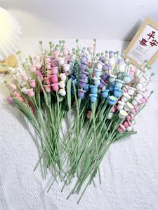 Handcrafted crochet lily of the valley bouquet in soft pastel colors on lace fabric