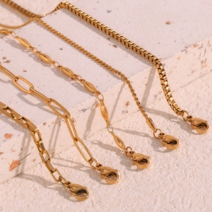 Macro shot of gold plated stainless steel box chains and figaro links with lobster clasps