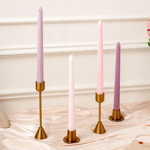 Juego elegante de velas cónicas de 25 cm en soportes dorados sobre seda color champán