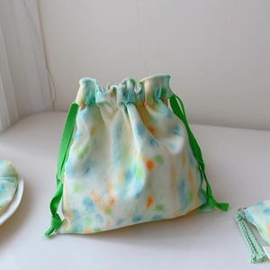 Detail of colorful tie-dye drawstring storage bag with mint green braided cords