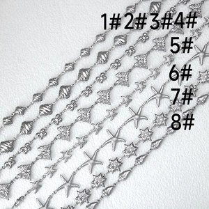 Detailed macro view of stainless steel butterfly and starfish charms for DIY jewelry making