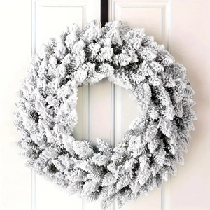 Snow-flocked Christmas wreath decoration for door and wall with winter snowy pine branches