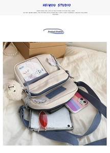 Détail du sac bandoulière en toile beige avec poche transparente et sangle bleue