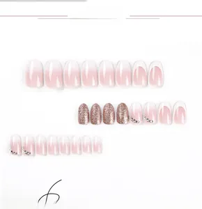 Detail of short French press-on nails with pink glitter and sparkling rhinestones