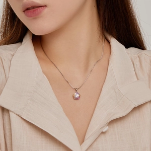 Close-up of a silver floral pendant with colorful zircon stones on a female model