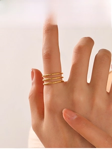Detail von dreilagigen 18K vergoldeten Edelstahlringen mit handgehämmerter Struktur