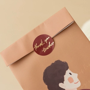 Brown paper gift bag with Thank You Teacher gold seal and smiling boy illustration