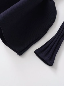Detailed close-up of dark blue ribbed knit fabric showing hem and cuff texture