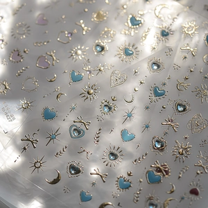 Detail of 3D embossed nail art stickers with golden stars, moon and butterfly patterns
