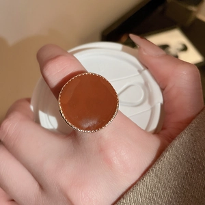 Gros plan d'une grande bague vintage en émail ambre avec monture perlée dorée