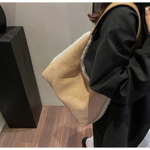 Detail of beige suede shoulder bag with white faux fur lining and plush trim accents