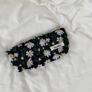 Macro view of white daisy embroidery on black fabric with a sewn woven brand label