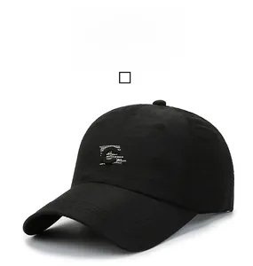 Close-up of the white embroidered letter C on the front of a black mesh baseball cap