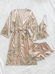 Detailed flat lay of three-piece satin pajama set with floral prints on champagne fabric
