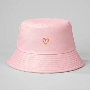 Detail of pink cotton bucket hat featuring an orange embroidered heart on the front
