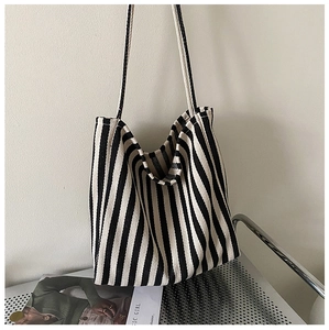 Detailed view of black and white striped canvas tote bag with woven fabric texture