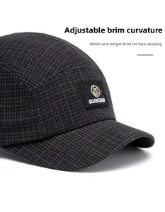 Detail view of the foldable brim on a grey plaid 5-panel baseball cap with logo patch