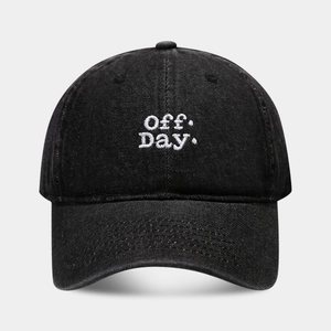 Close-up of Off Day. white embroidery on black washed cotton baseball cap texture