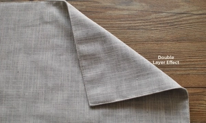 Detailed close-up showing grey cotton-linen texture and double-layered sewing on table napkin