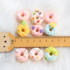 9er Set bunte Mini-Harz-Donuts für DIY-Bastelarbeiten und Haarschmuck auf weichem Plüschgrund