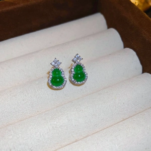 Detailed close-up of emerald green gourd stud earrings with zircon inlay in a jewelry box