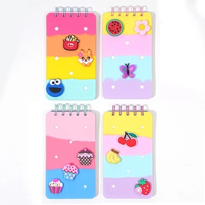 Detail of four colorful spiral notebooks with unique 3D PVC charms and star cutout covers