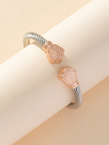 Dettaglio del bracciale ritorto in acciaio inossidabile con punte a petalo rosa